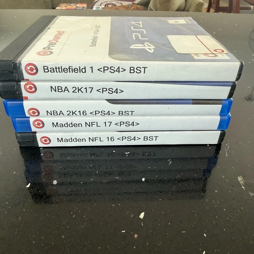 Stack of PS4 Game Cases with White Spine Labels (NBA & Madden + Battlefield)